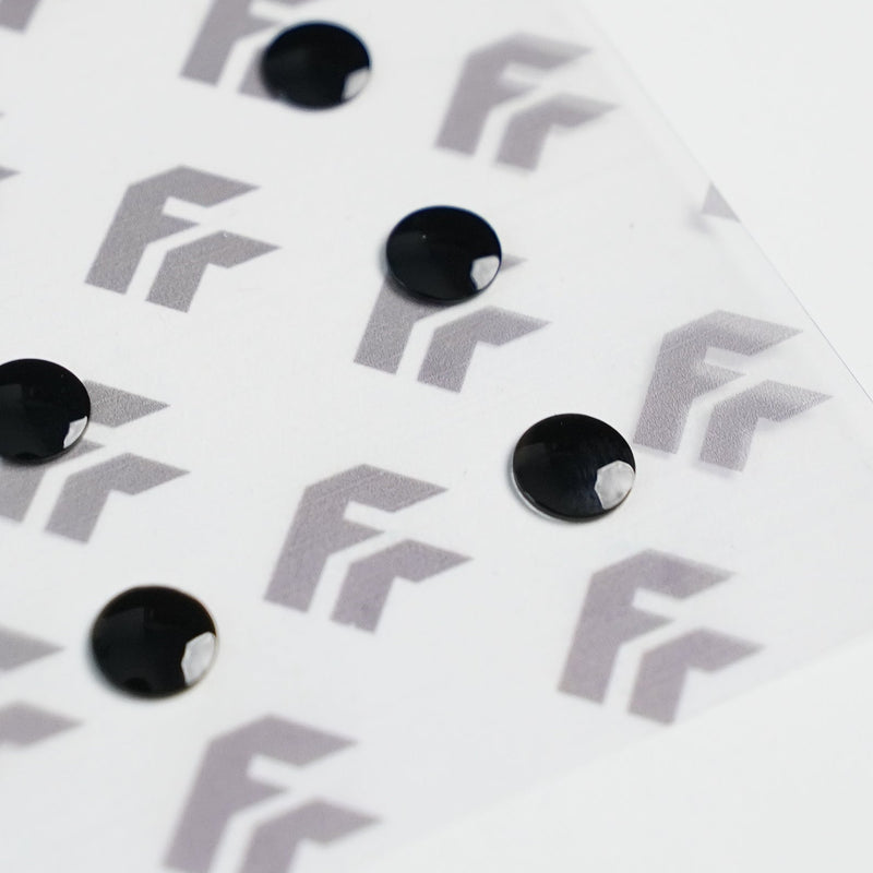 Clear plastic sheet with black dots on a white background